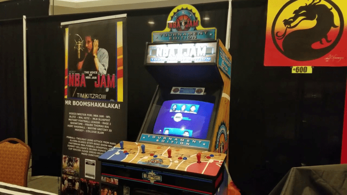 Photo of Tim Kitzrow’s booth at the 2022 Houston Arcade Expo, showing an NBA Jam arcade cabinet.