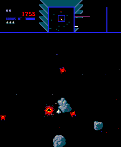 Screenshot of the game Sinistar, showing the player’s ship close to a Planetoid. There are enemy ships above and to the lower-right, with a third one exploding to the player’s left.